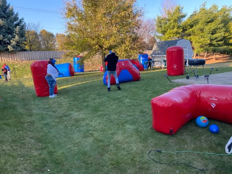 Gellyball battle with inflatable bunkers in a backyard